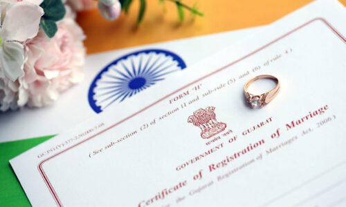 Indian Certificate of registration of marriage blank document and wedding ring on flag close up