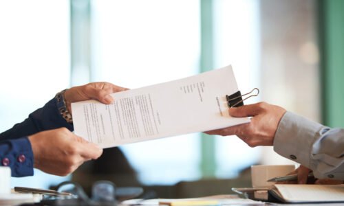 Business person giving partnership agreement to coworker