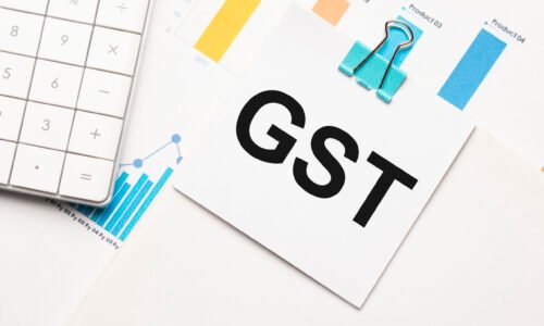 gst text concept. Office workplace table with calculator, graphs, reports and the text Budget 2021 on a small piece of paper on multicolored background.